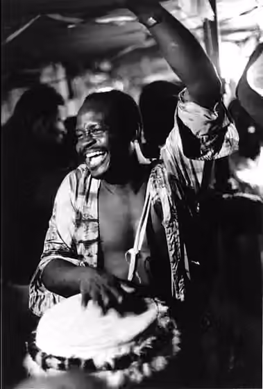 Haitian Vodou drumming — This photograph shows Master Drummer Frisner Augustin playing for a Haitian Vodou dance in a Brooklyn, New York, basement in the early 1980s.