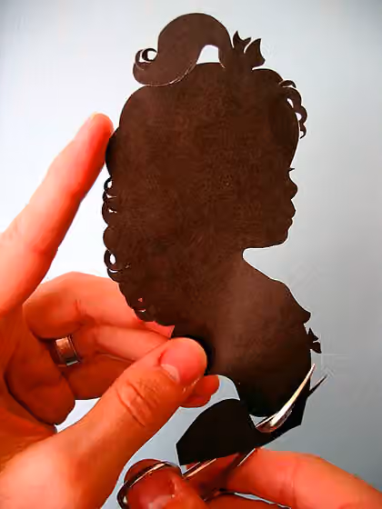 Papercutting — Hands cutting silhouette of girl Author Karl Johnson