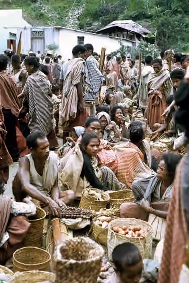 orang Kemak — O convívio no bazar,onde se trocavam produtos e se mascava.A masca era uma mistura de folha de bétel,noz de areca e cal que produzia uma pasta avermelhada.Na boca ficava entalada no lábio.
