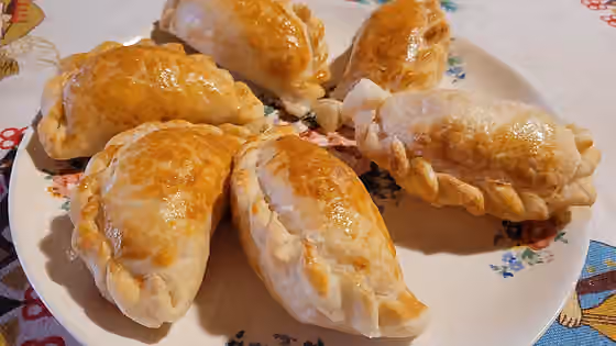 Empanada — Empanadas argentinas de jamón y queso con orégano y tomate, pinceladas con huevo batido.
