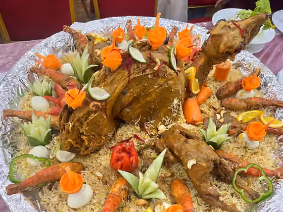 Shagorana — A Shagorana platter served at a Bangladeshi wedding featuring a whole roasted goat, lobsters, chicken roasts, eggs, aromatic polao, and decorative cut salads.