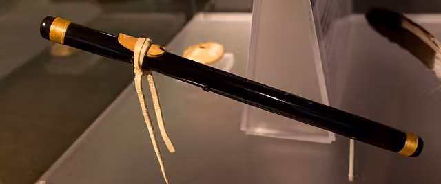Seruling hitam dengan hiasan berwarna emas dipajang di museum.