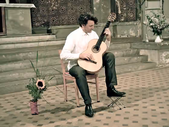 Musical improvisation — The photo shows Andreas Paolo Perger playing "Gravur/ Gravure - improvised compositions" live at Zionskirche Berlin on a Langenbacher concert guitar.