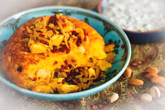 Tahchin — Saffron infused crisp rice cake cooked with chicken and yoghurt.